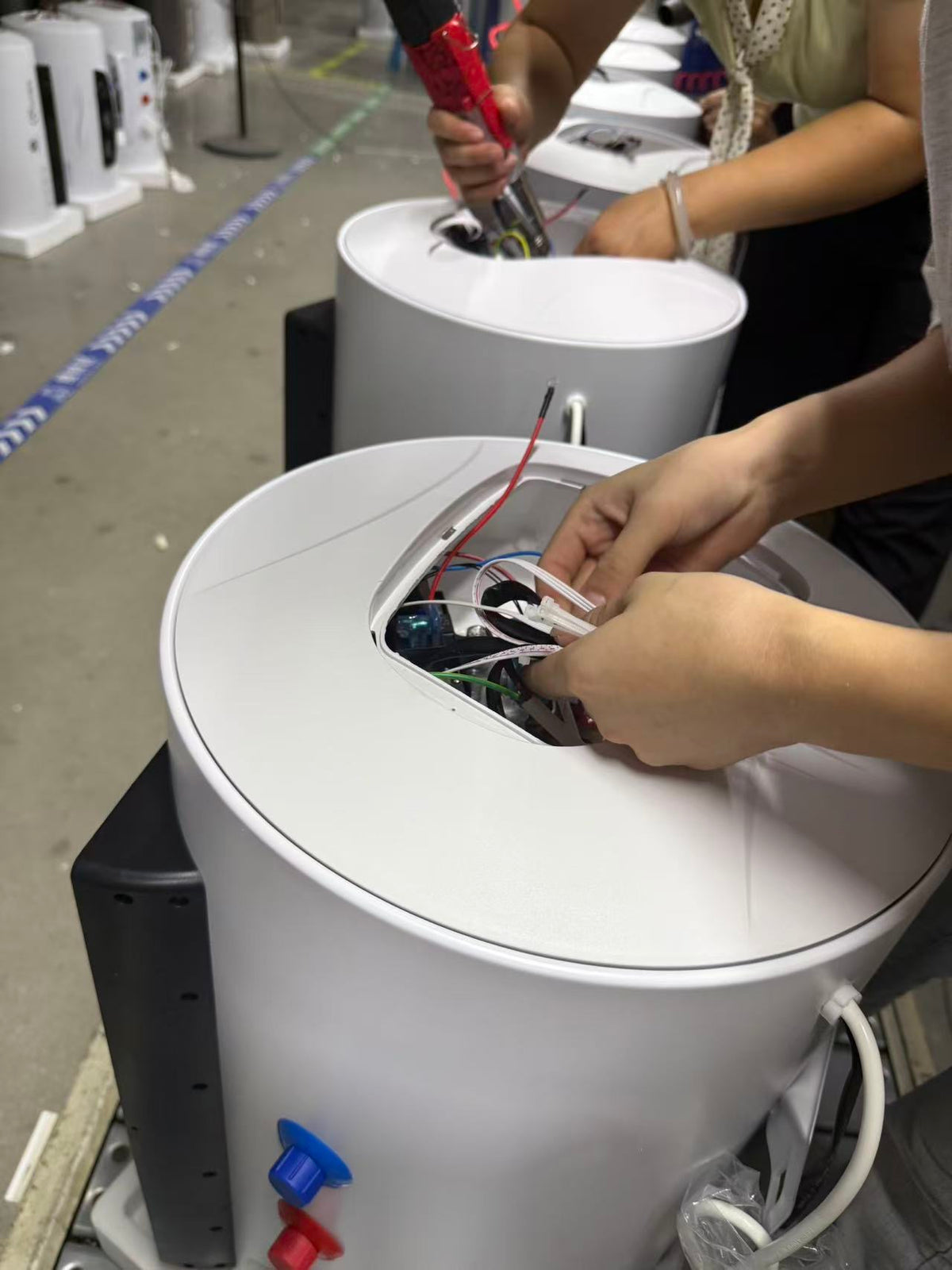 Technician operating laser welding equipment for water heater tank production